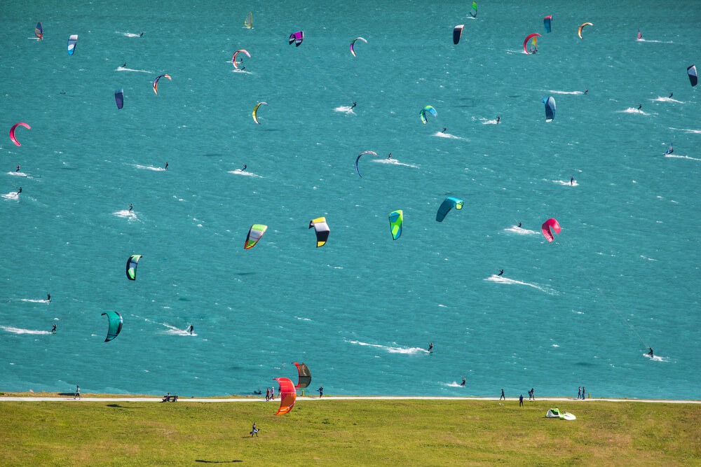 Many Kitesurfers and Windsurfers in a Lake