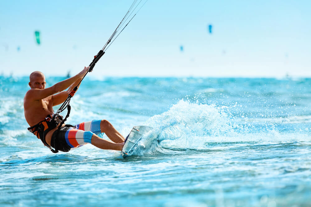 Recreational Sports. Man Kiteboarding In Sea Water